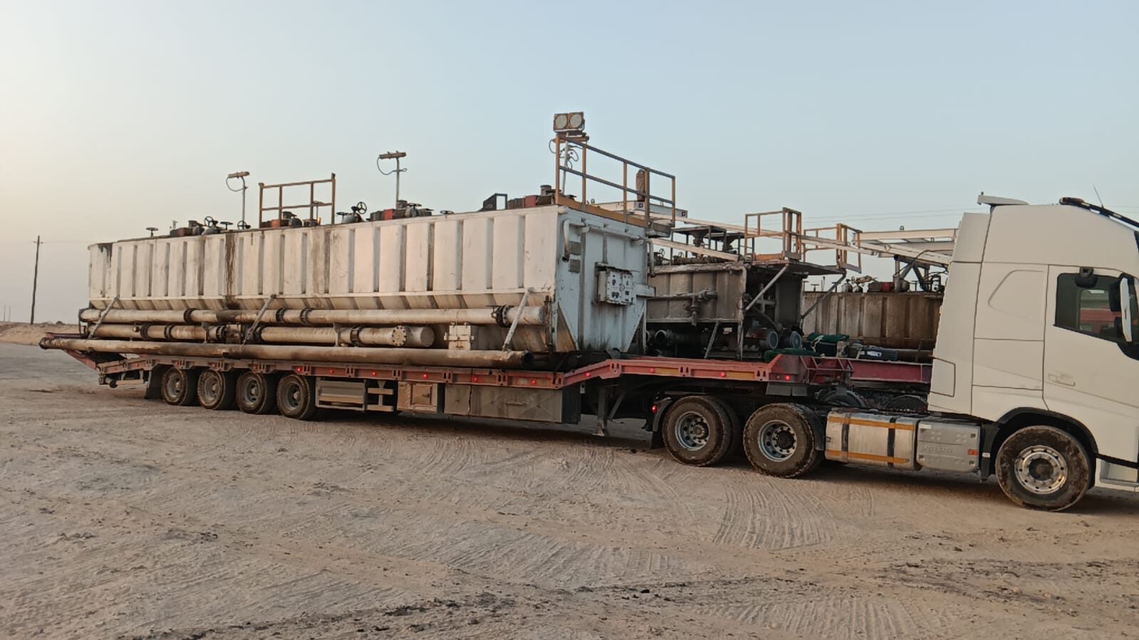 Oilfield equipment at dusk loaded on flatbed